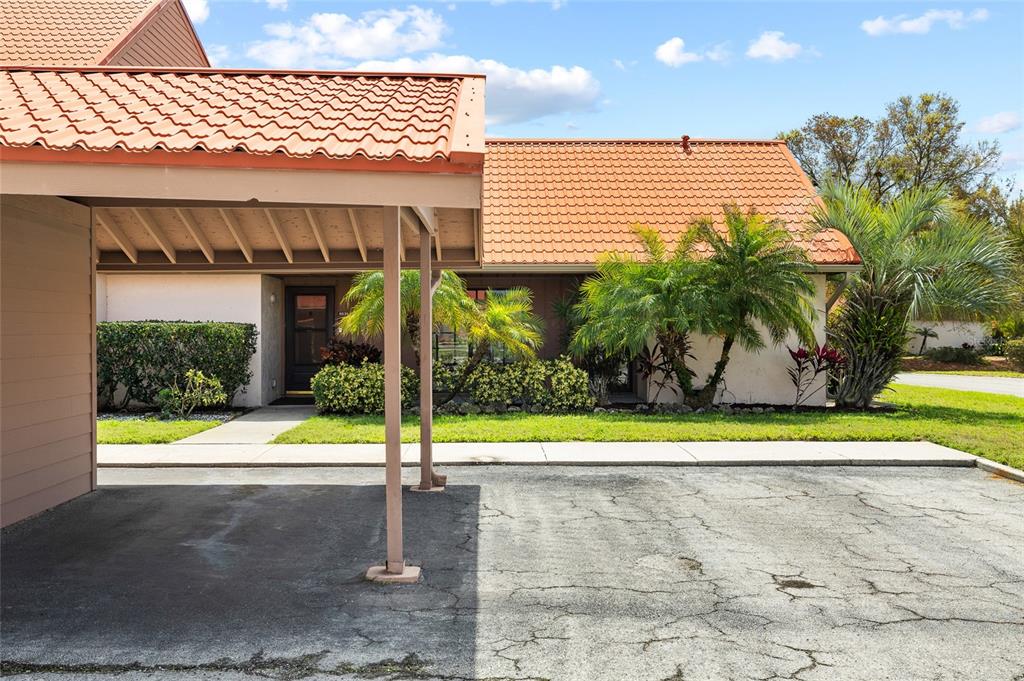 A single-story house with a terracotta tile roof and a covered carport entrance — 6535 DRAW LANE UNIT 85, SARASOTA, FL