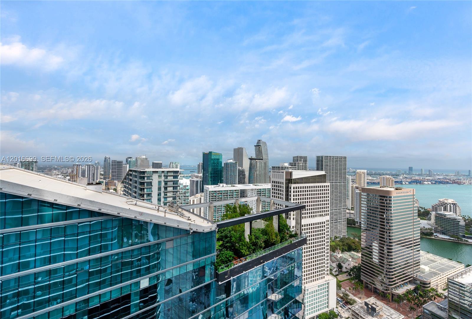 A high-angle view shows a modern glass skyscraper with a rooftop garden overlooking Miami — 801 S Miami Ave # 5207, Miami FL 33130, MIAMI, FL