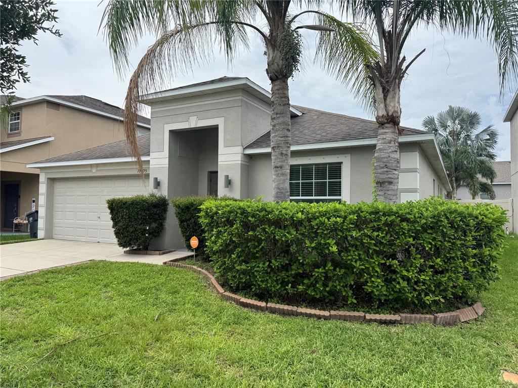 A single-story house with a two-car garage, palm trees, and a manicured hedge — 10405 SUMMER AZURE DRIVE, RIVERVIEW, FL