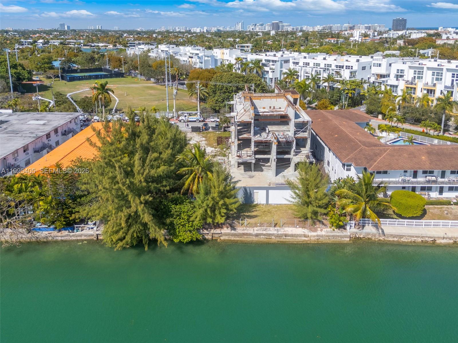 An aerial view shows a waterfront construction site with a partially built concrete structure — 10 S Shore Dr, Miami Beach FL 33141, MIAMI BEACH, FL