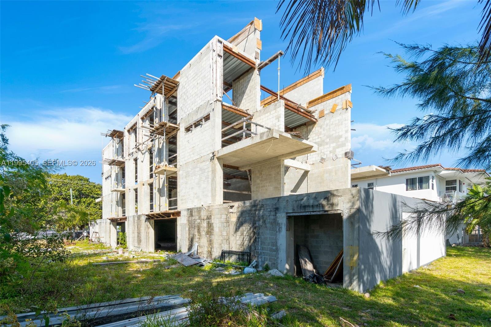 An unfinished multi-story concrete building stands under construction on a grassy lot — 10 S Shore Dr, Miami Beach FL 33141, MIAMI BEACH, FL