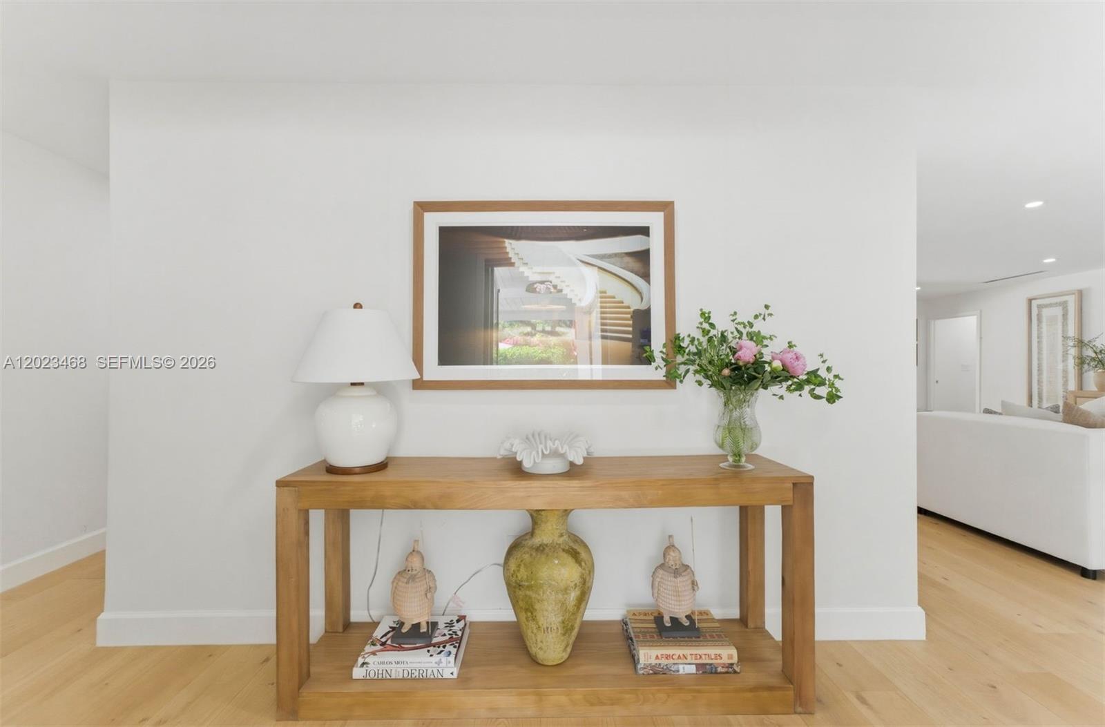 A wooden console table sits against a white wall beneath a framed photograph — 7350 SW 65th Ave, South Miami FL 33143, SOUTH MIAMI, FL