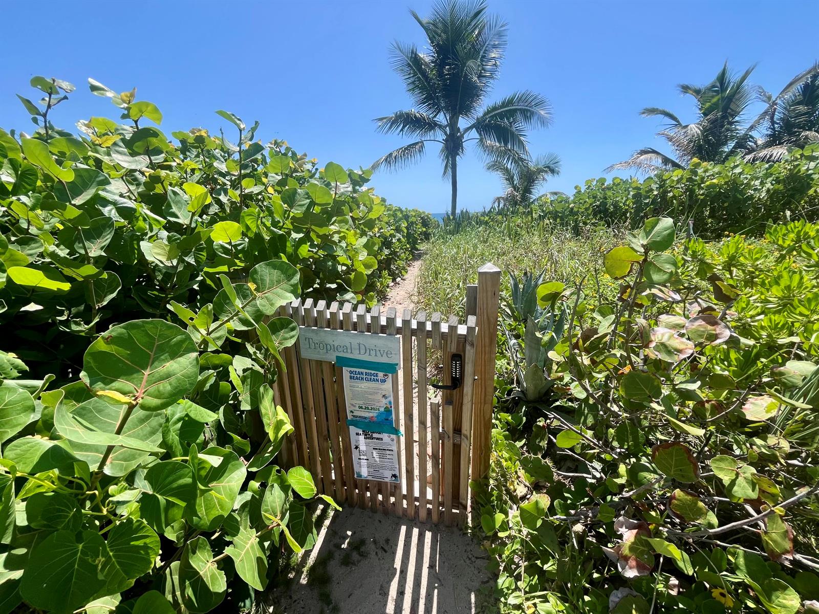 A wooden gate with a keypad lock leads to a sandy path toward the beach — 14 Tropical Drive, Ocean Ridge FL 33435, OCEAN RIDGE, FL