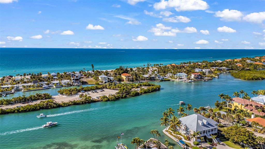 A single-story house with a stone facade and a paved walkway under a sunset sky — 312 BAYSHORE ROAD, NOKOMIS, FL