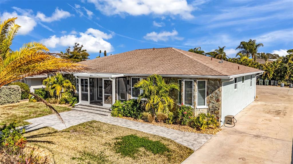 A single-story house with a stone facade, a hip roof, and a paved walkway — 312 BAYSHORE ROAD, NOKOMIS, FL