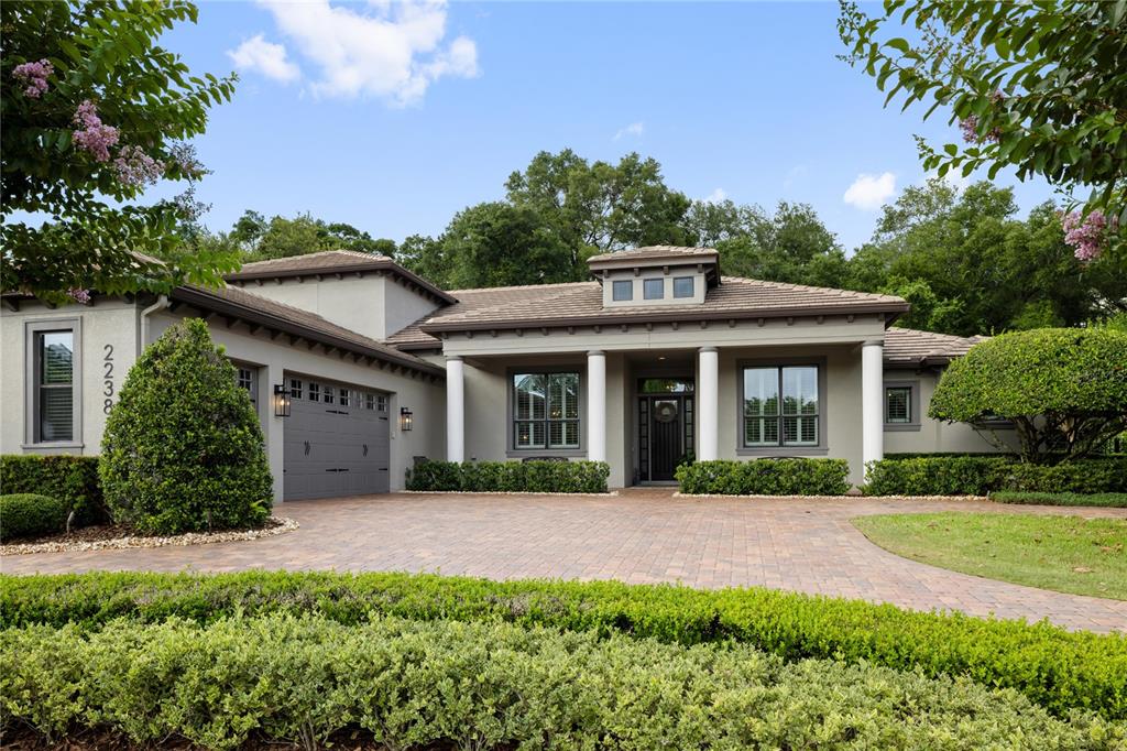 A single-story house with a paved driveway, white columns, and a gray garage door — 2238 SOARING EAGLE PLACE, LAKE MARY, FL