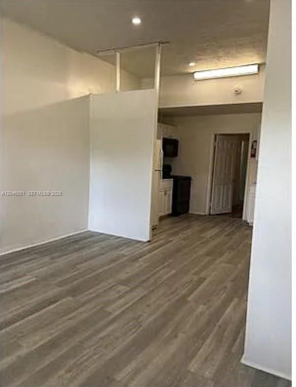 An interior view showing a living area with light wood flooring and a partial wall — 2205 Roosevelt St # 2, Hollywood FL 33020, HOLLYWOOD, FL