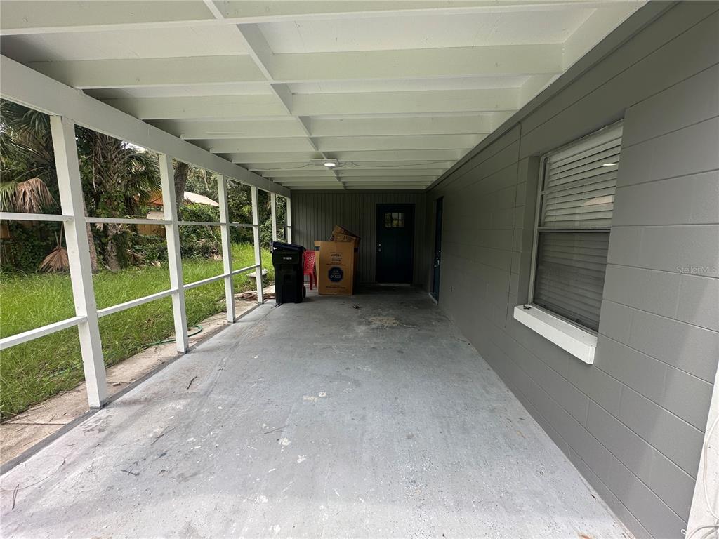 A gray single-story house with a blue front door and an attached screened-in carport — 25527 ANTLER STREET, CHRISTMAS, FL