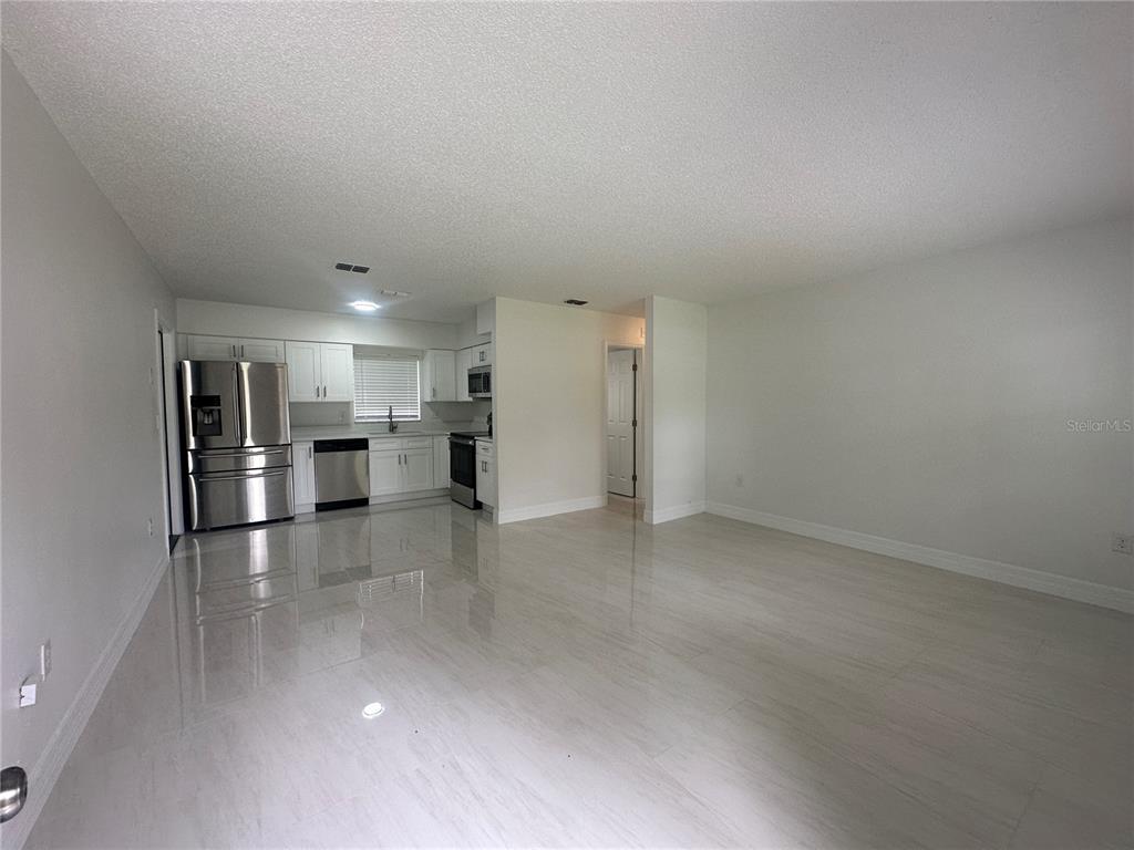 A covered concrete patio features white framing, a gray wall, and a blue door — 25527 ANTLER STREET, CHRISTMAS, FL