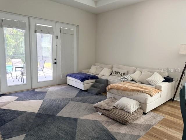 A living room features a large sectional sofa, a geometric rug, and glass patio doors — 1647 KEY BAY TRAIL, KISSIMMEE, FL