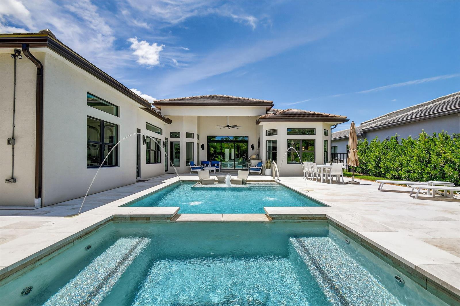 A modern house exterior features a swimming pool with a spa and water fountains — 11158 Glen Orchard Lane, Boynton Beach FL 33473, BOYNTON BEACH, FL