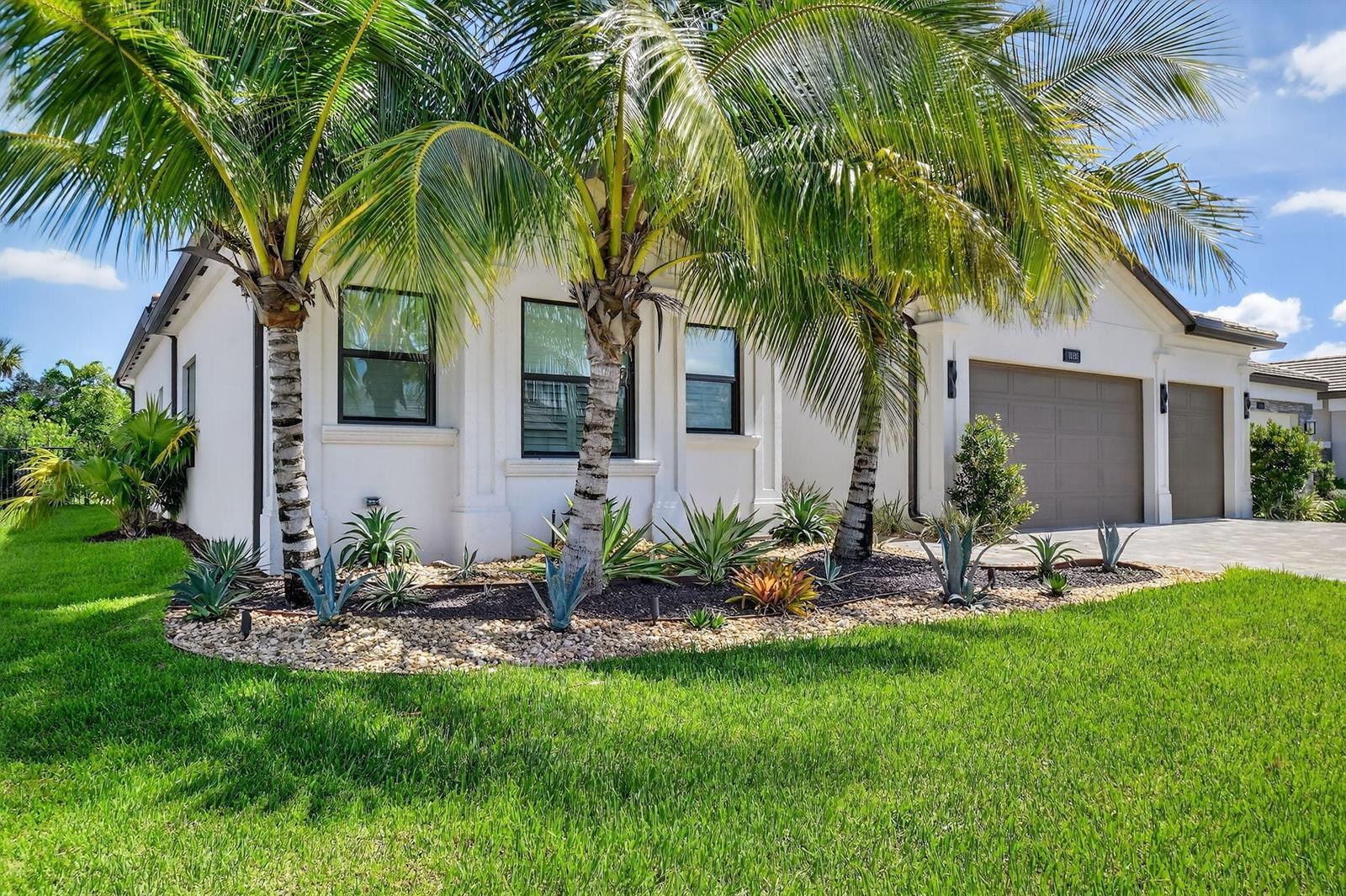 A white house exterior features palm trees and desert-style landscaping in the front yard — 11158 Glen Orchard Lane, Boynton Beach FL 33473, BOYNTON BEACH, FL