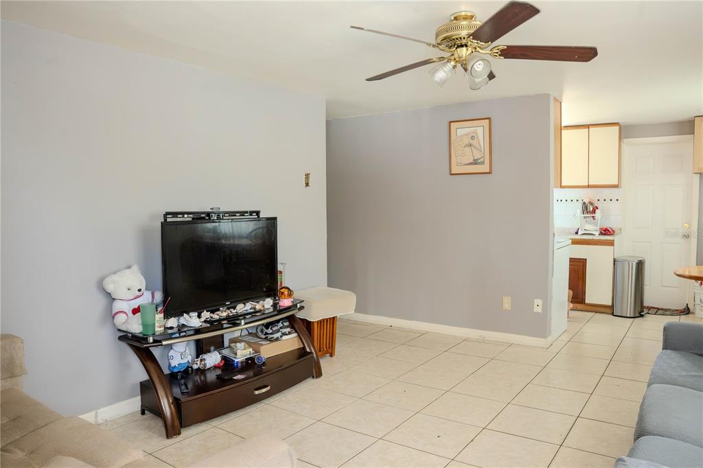 A living room with tile floors, a ceiling fan, and a television on a stand — 636 DOGWOOD COURT, DUNEDIN, FL