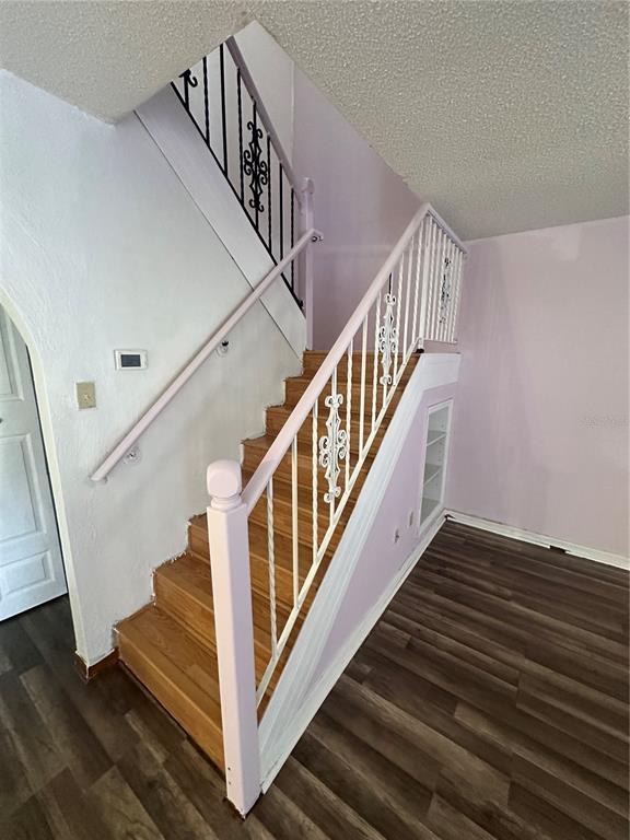 A staircase with wooden treads and white railings leads upward in a room with light-colored walls — 2016 OAK MEADOW CIRCLE, SOUTH DAYTONA, FL