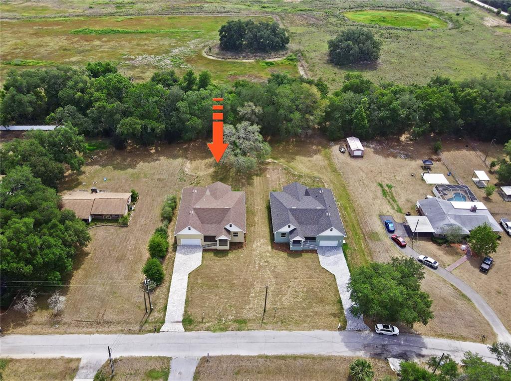 An aerial view shows two houses with driveways situated on a large, grassy lot — 12500 GREEN OAK LANE, DADE CITY, FL