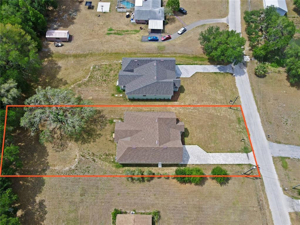An aerial view shows a single-story house with a brown roof on a large lot — 12500 GREEN OAK LANE, DADE CITY, FL