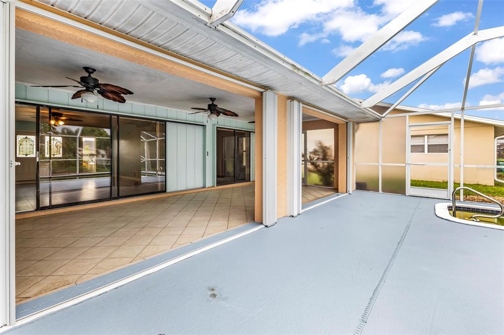 A covered patio with tiled flooring leads into an interior room through large sliding glass doors — 2399 RIO DE JANEIRO AVENUE, PUNTA GORDA, FL