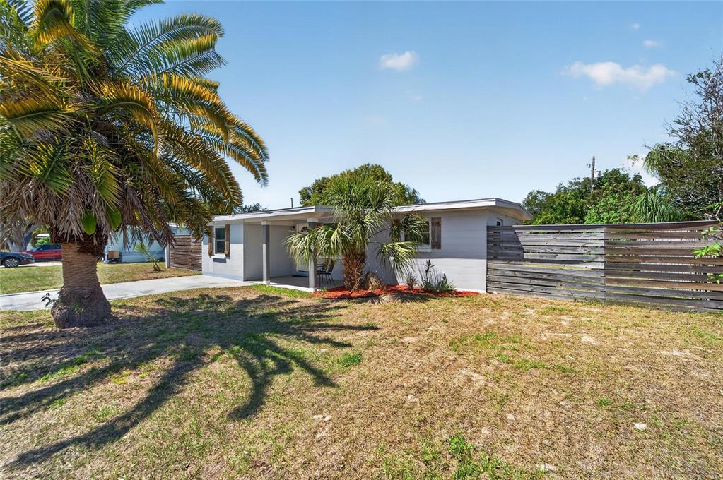 A single-story house with a palm tree in the front yard and a wooden fence — 10353 110TH AVENUE, LARGO, FL