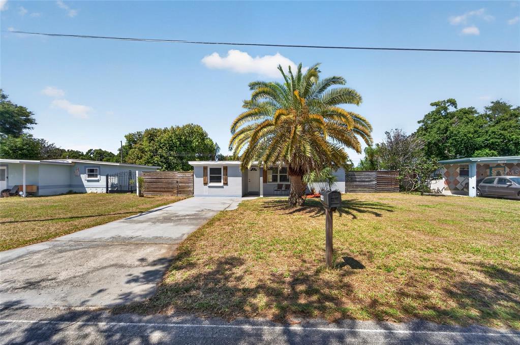 A single-story house with a palm tree in the front yard and a concrete driveway — 10353 110TH AVENUE, LARGO, FL