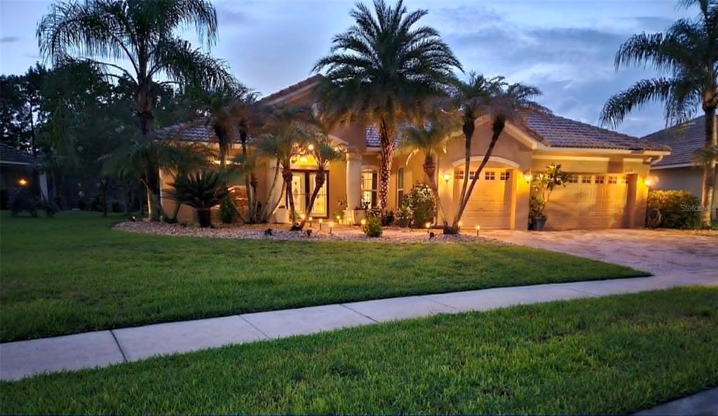A single-story stucco house with a tile roof and palm trees at dusk — 3524 SHOREWOOD DRIVE, KISSIMMEE, FL