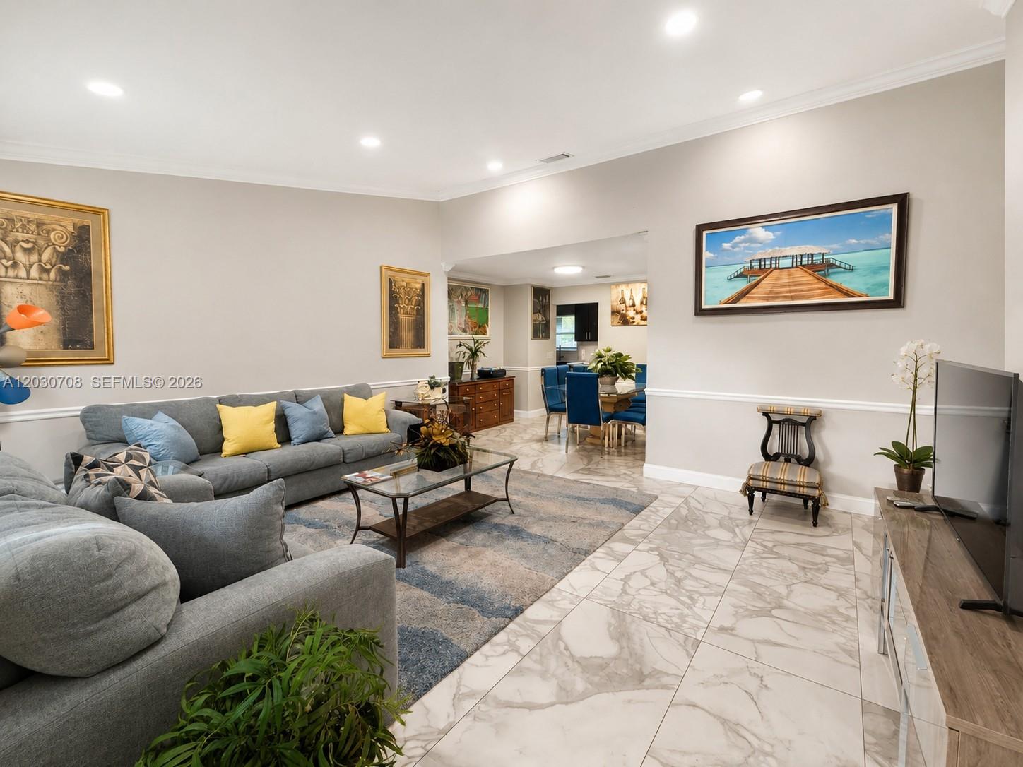 A living room features gray sofas, a glass coffee table, and marble tile flooring — 1800 Wisteria St, Wellington FL 33414, WELLINGTON, FL
