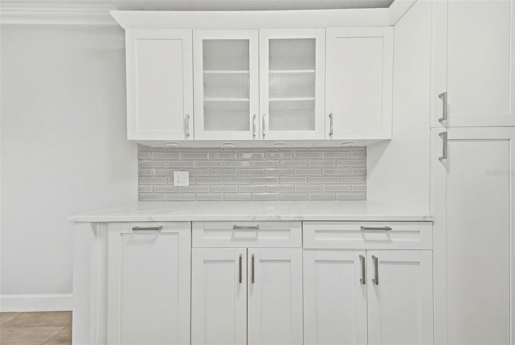 A kitchen area features white cabinets, a marble countertop, and a gray subway tile backsplash — 4141 BAYSHORE BOULEVARD UNIT 306, TAMPA, FL