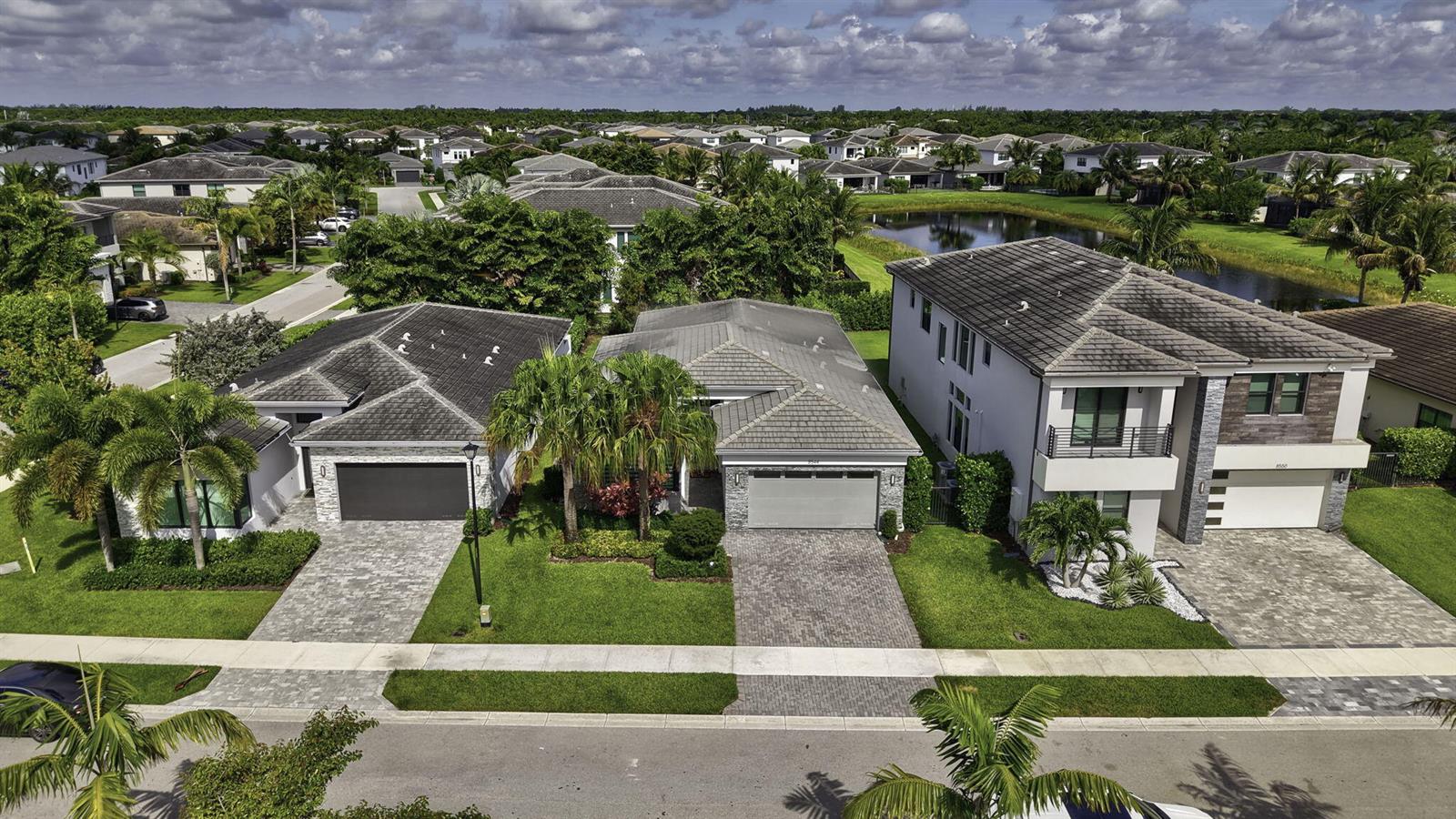 An aerial view shows three suburban houses with paved driveways and palm trees — 8544 Apple Falls Lane, Boca Raton FL 33496, BOCA RATON, FL