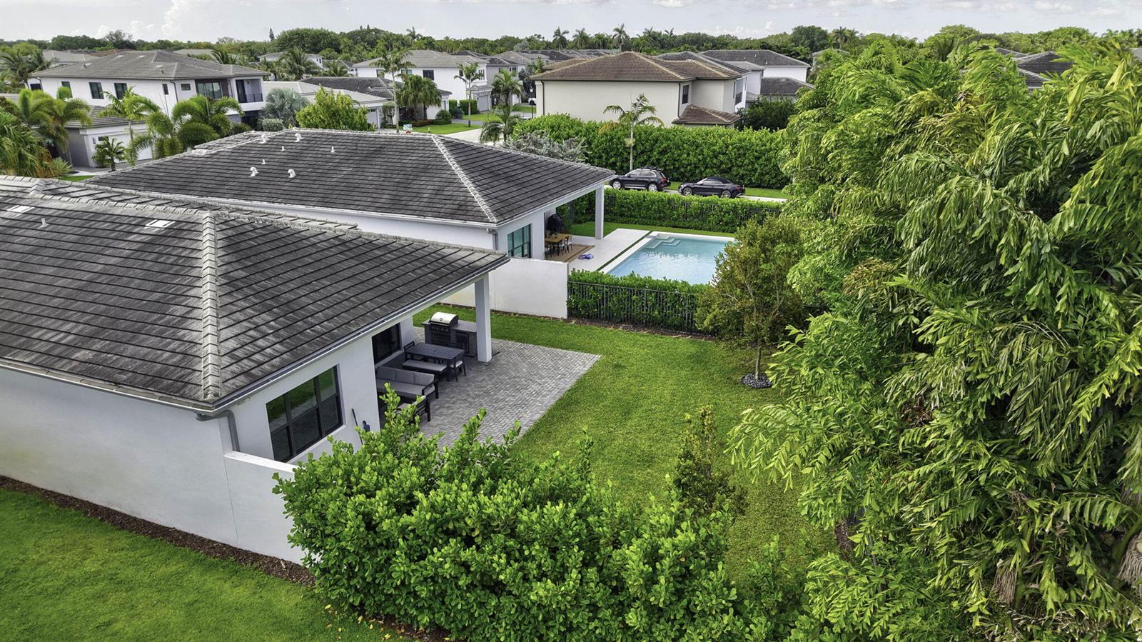 An aerial view of a house with a tiled roof, patio, and backyard swimming pool — 8544 Apple Falls Lane, Boca Raton FL 33496, BOCA RATON, FL