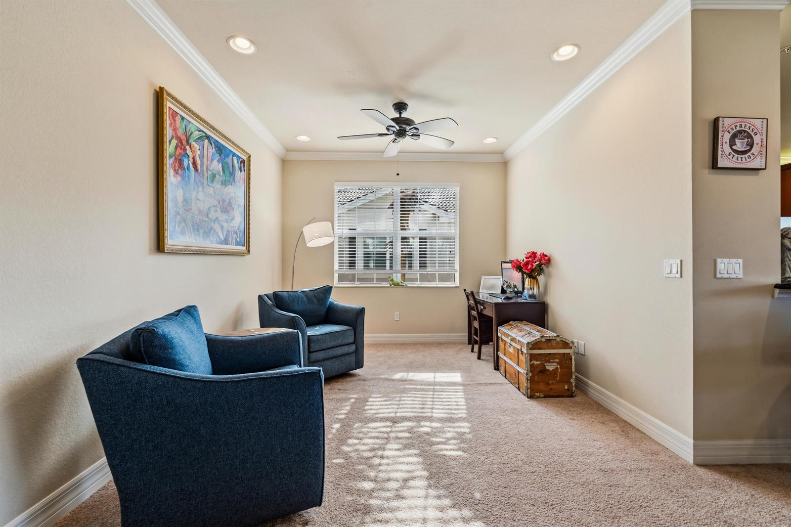 A carpeted home office features two blue armchairs, a wooden desk, and a vintage trunk — 6513 Monterey Point # 201, Naples FL 34105, NAPLES, FL
