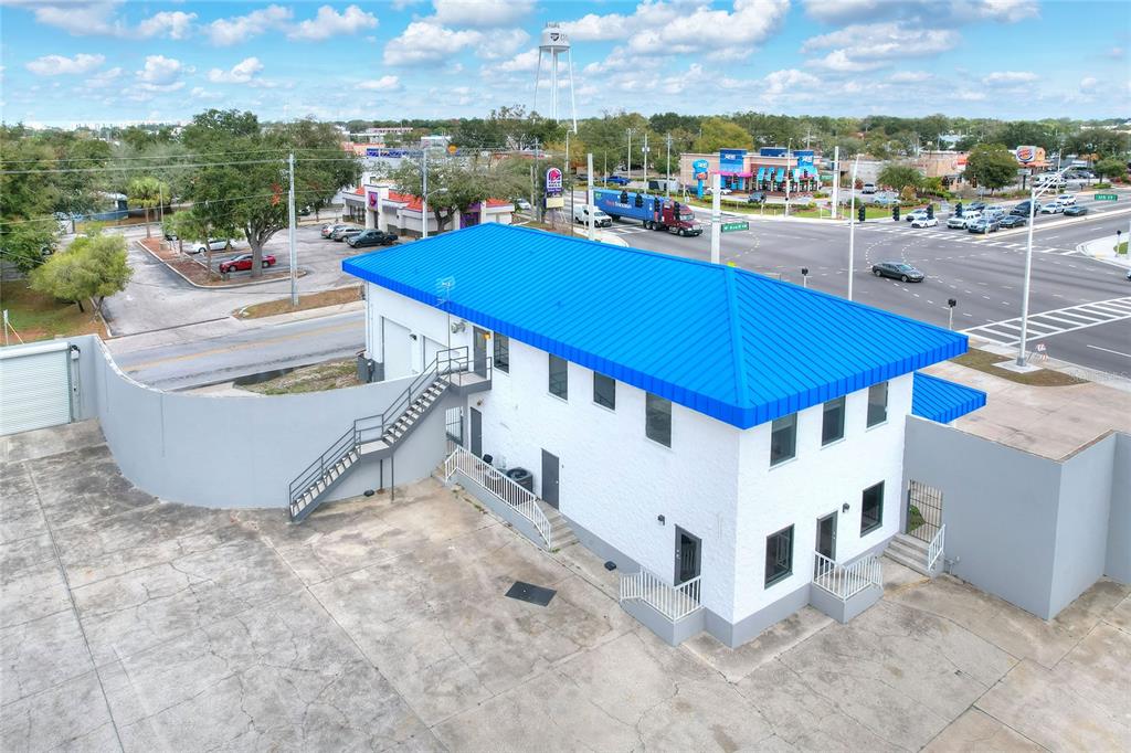 An aerial view of a white two-story commercial building with a bright blue metal roof — 1803 3RD STREET SW, WINTER HAVEN, FL