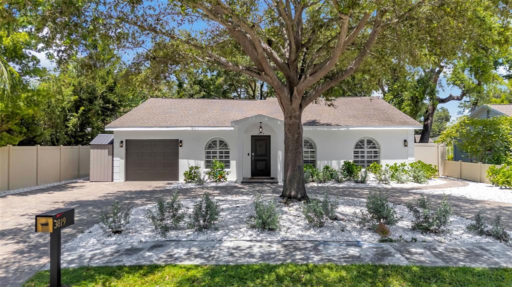 A backyard features a swimming pool with a raised spa, patio furniture, and a small house — 3819 W SAN MIGUEL STREET, TAMPA, FL