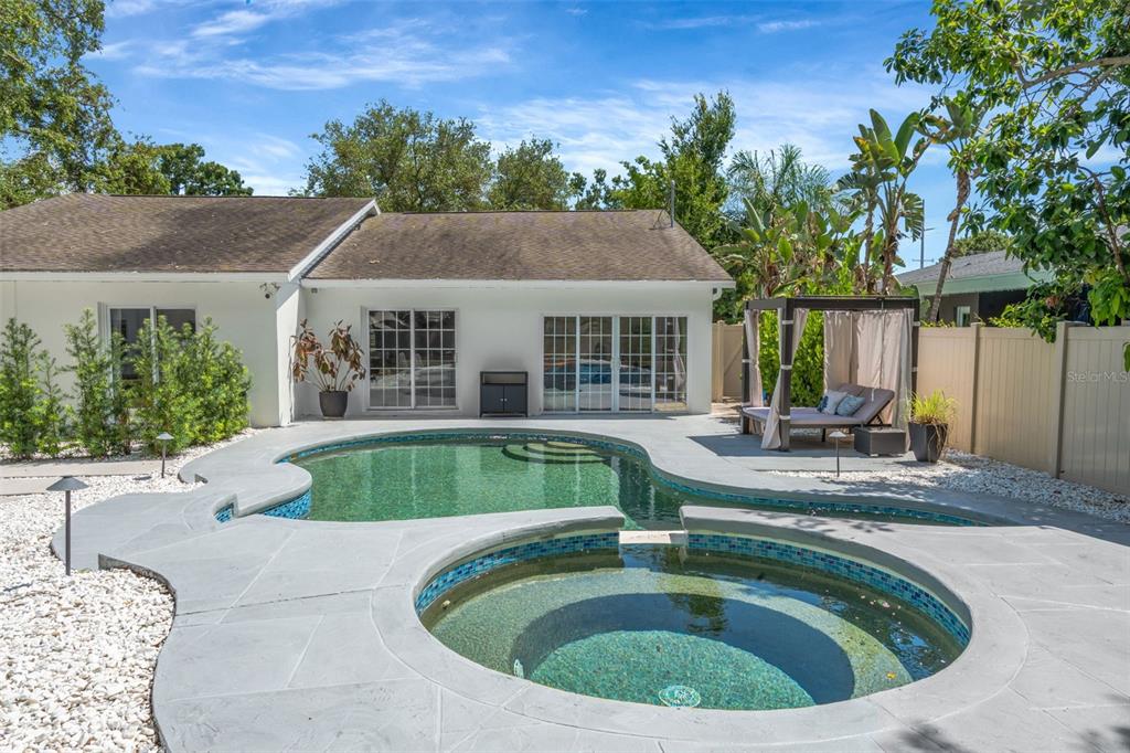 A single-story house with a paved driveway, a large tree, and white landscaping stones — 3819 W SAN MIGUEL STREET, TAMPA, FL