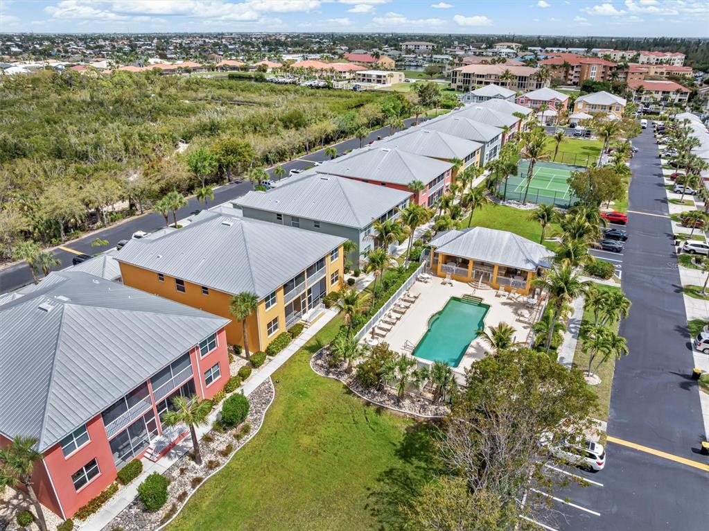 An aerial view shows multi-story apartment buildings, a swimming pool, and a tennis court — 2002 BAL HARBOR BOULEVARD UNIT 312, PUNTA GORDA, FL
