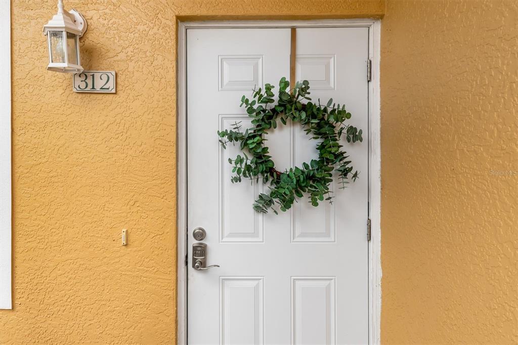 A white front door with a green wreath and a house number 312 sign — 2002 BAL HARBOR BOULEVARD UNIT 312, PUNTA GORDA, FL