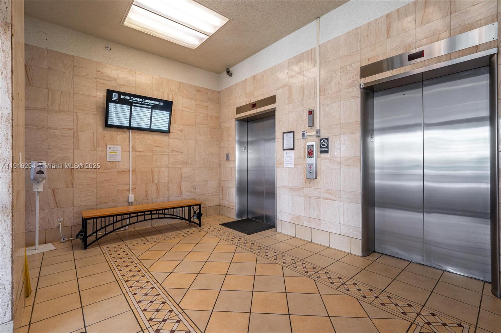 An elevator lobby features tiled walls, a bench, and two stainless steel elevator doors — 1720 Harrison St # 10G, Hollywood FL 33020, HOLLYWOOD, FL