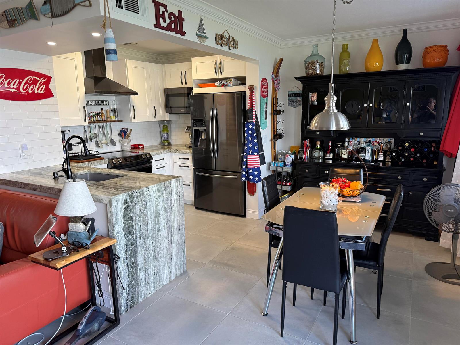 A kitchen and dining area featuring stone countertops, white cabinetry, and a black hutch — 1201 S Riverside Drive # 106, Pompano Beach FL 33062, POMPANO BEACH, FL