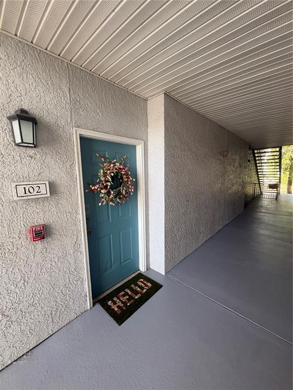 The exterior entrance of apartment 102 features a blue door, a wreath, and a welcome mat — 5821 LEGACY CRESCENT PLACE UNIT 102, RIVERVIEW, FL