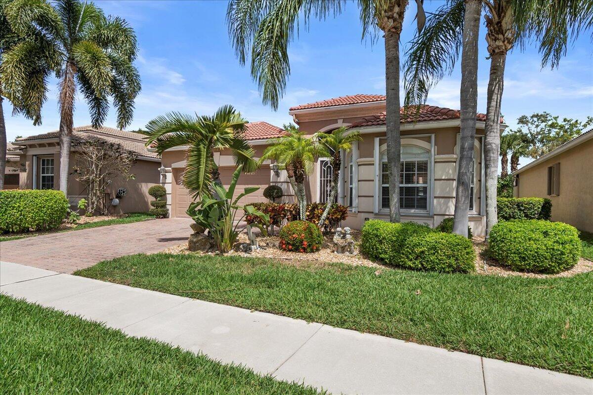 A single-story suburban house with a tile roof, palm trees, and a paved driveway — 8839 Via Avellino, Lake Worth FL 33467, LAKE WORTH, FL