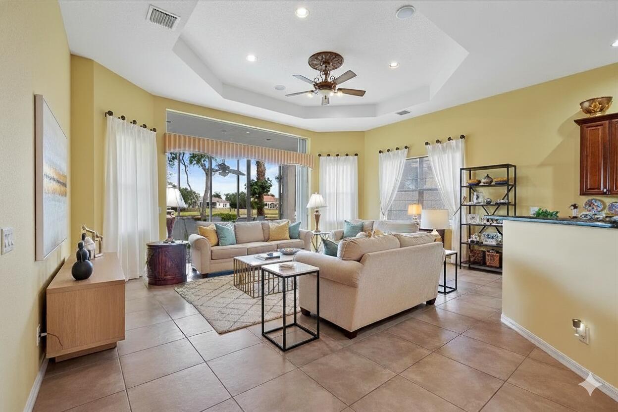 A living room with tile floors, a tray ceiling, and a large sliding glass door — 8839 Via Avellino, Lake Worth FL 33467, LAKE WORTH, FL