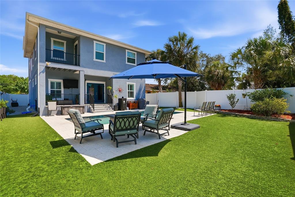 A two-story blue house with a backyard pool, patio furniture, and an umbrella — 6709 INTERBAY BOULEVARD, TAMPA, FL