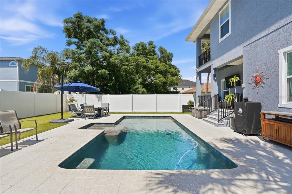A backyard features a rectangular swimming pool, a patio, and a white privacy fence — 6709 INTERBAY BOULEVARD, TAMPA, FL