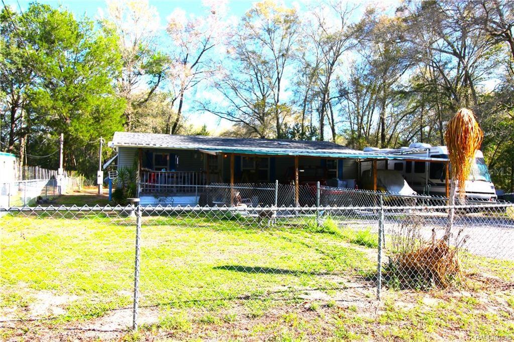 A single-story house with a covered porch and an adjacent RV parked behind a fence — 4629 E BOW N ARROW LOOP, INVERNESS, FL