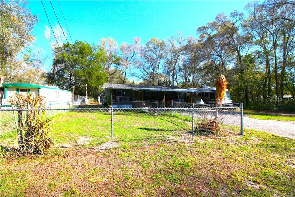 A chain-link fence encloses a yard in front of a house and a parked RV — 4629 E BOW N ARROW LOOP, INVERNESS, FL