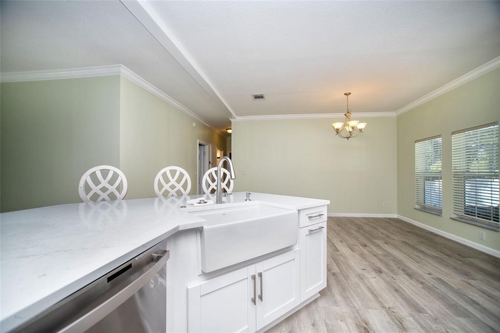 A white kitchen island with a farmhouse sink faces an open dining area with windows — 415 DR ML KING JR STREET N, SAFETY HARBOR, FL