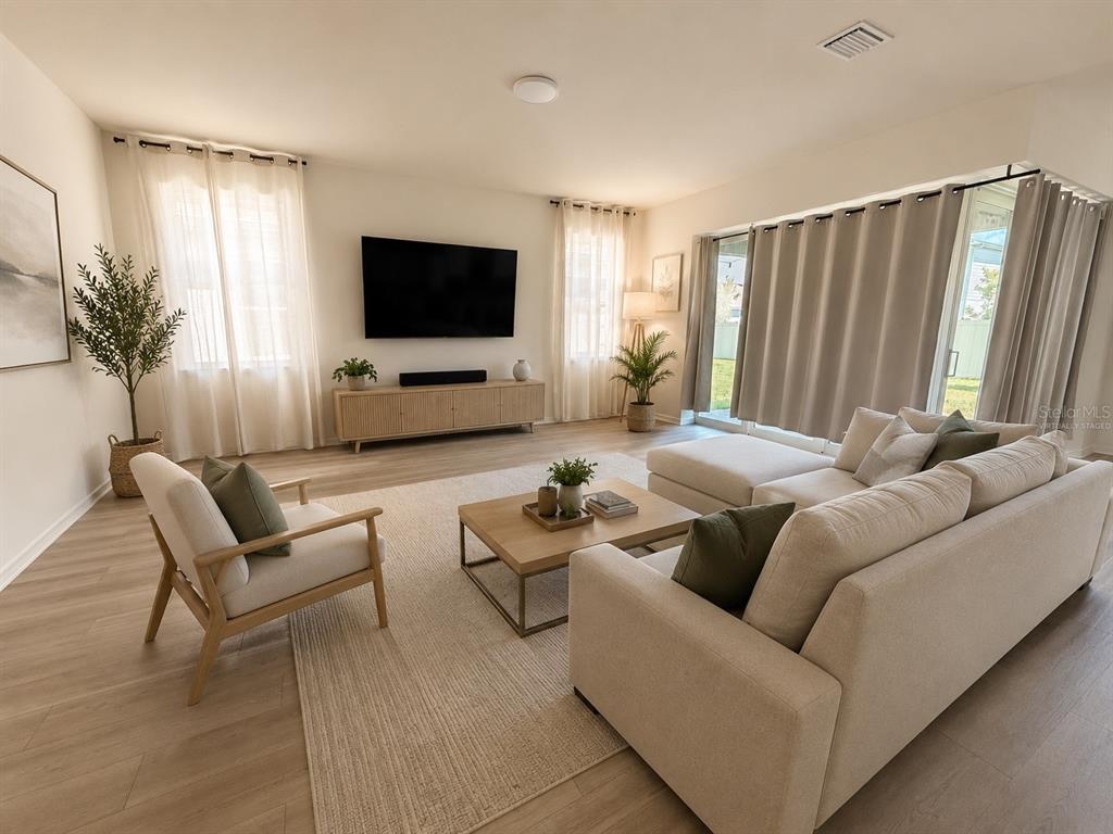 A living room features a sectional sofa, armchair, coffee table, and a wall-mounted television — 2602 AUTUMN PEACE DRIVE, KISSIMMEE, FL