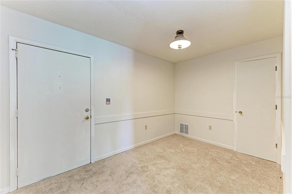A room with beige carpet, white walls, a ceiling light, and two closed white doors — 5503 FOUNTAIN LAKE CIRCLE UNIT A203, BRADENTON, FL