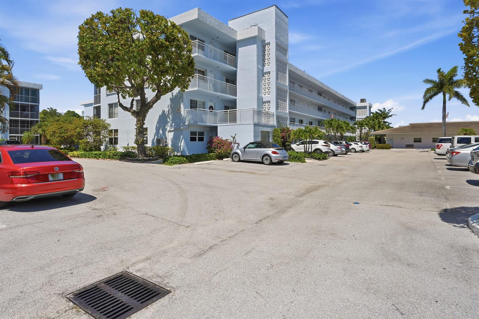 A multi-story apartment building with balconies stands next to a parking lot with cars — 2008 S Federal Highway # 101, Boynton Beach FL 33435, BOYNTON BEACH, FL