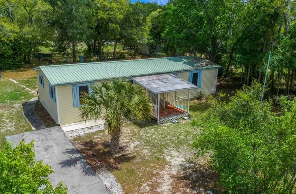 An aerial view of a single-story manufactured home with a green metal roof and porch — 5415 S DOYLE TERRACE, HOMOSASSA, FL