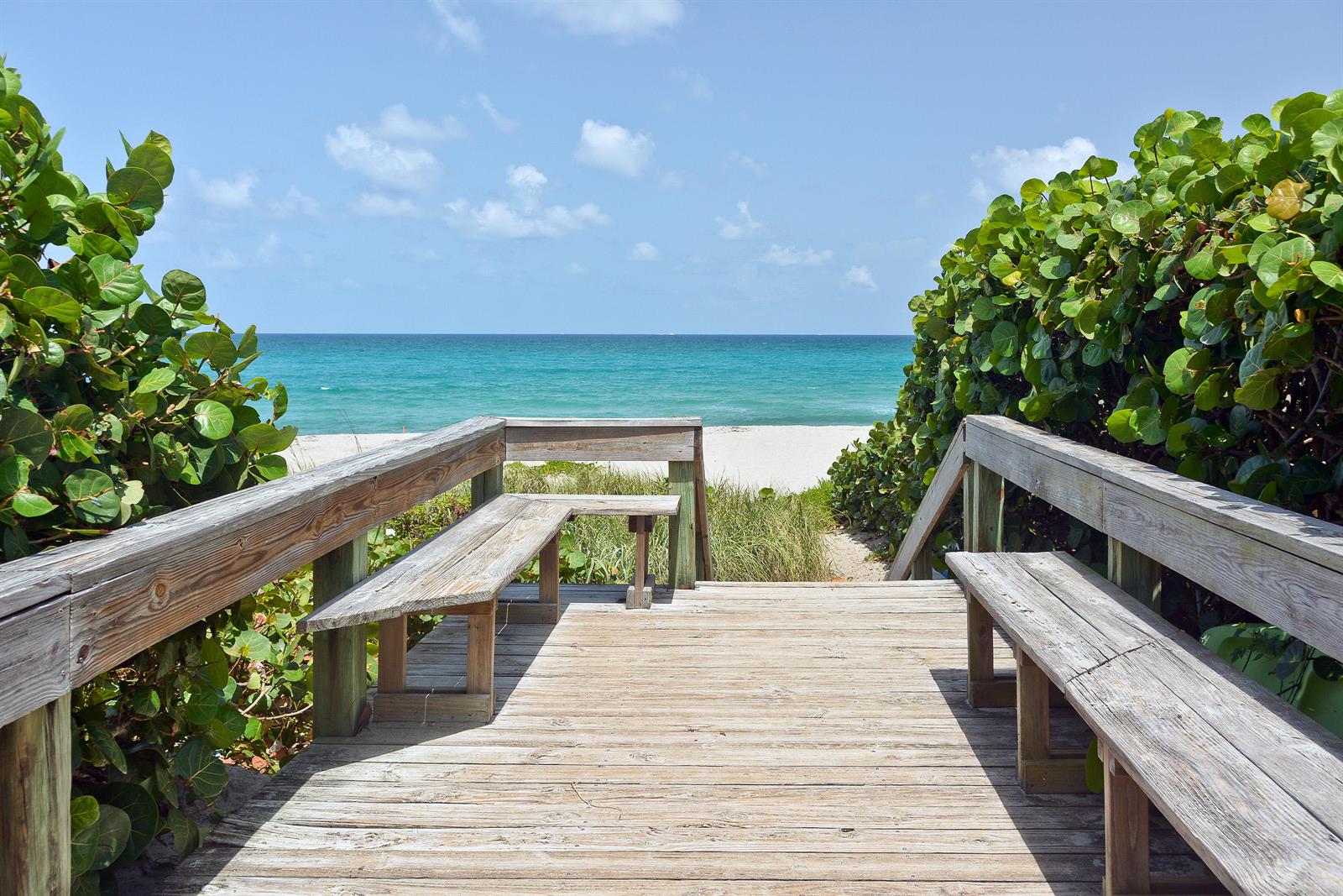 A wooden boardwalk with built-in benches leads to a sandy beach and the ocean — 50 Celestial Way # 8e, Juno Beach FL 33408, JUNO BEACH, FL
