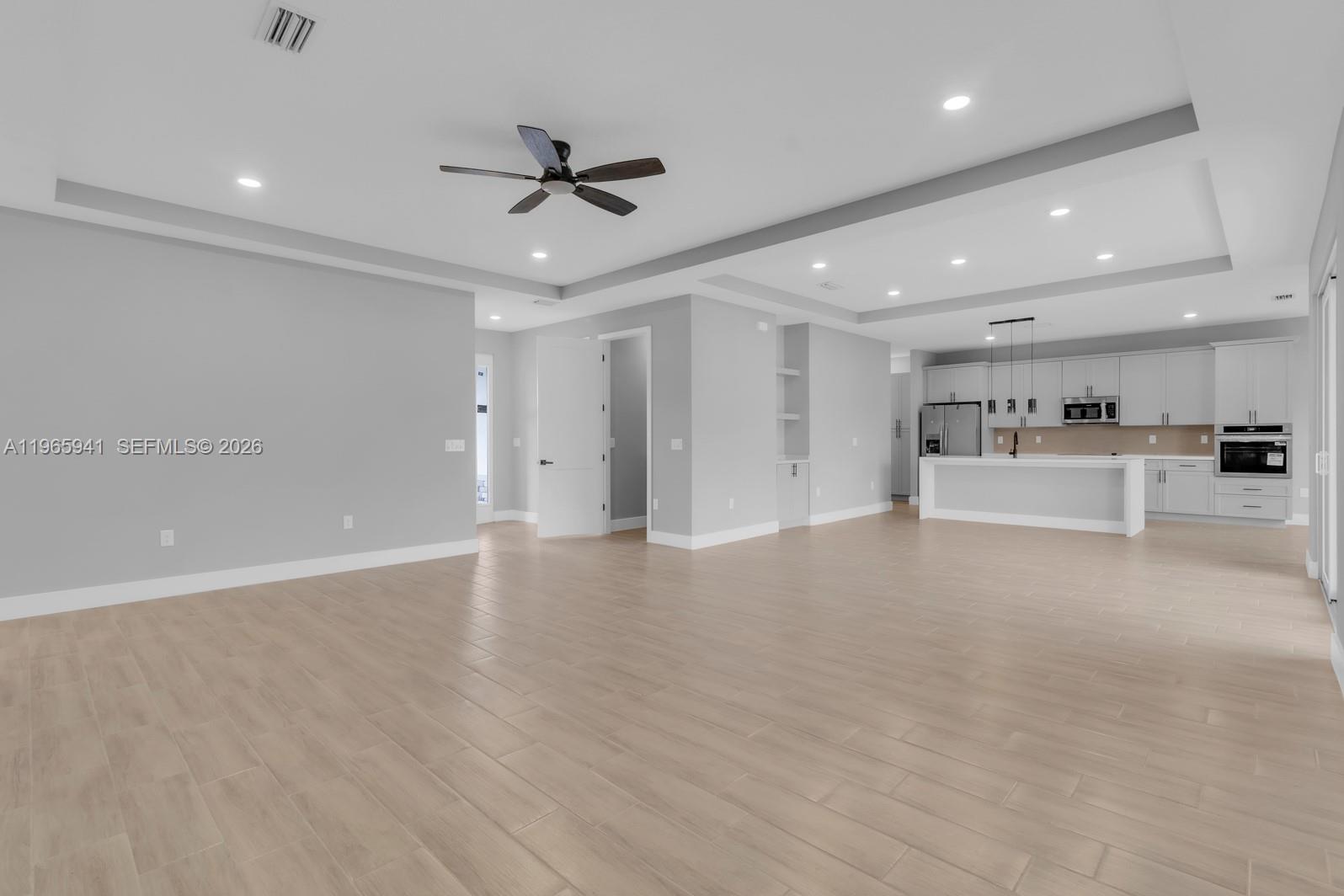 An open-concept living area features light gray walls, tile flooring, and a modern kitchen — 1821 MISSOURI, Palm Bay FL 32907, PALM BAY, FL